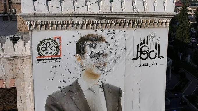 A bullet-riddled portrait of Syrian President Bashar al-Assad, which adorned the Hama municipality building, after it was defaced following the capture of the city by rebel fighters, Dec. 6, 2024. (Credit: Omar Haj Kadour/AFP)