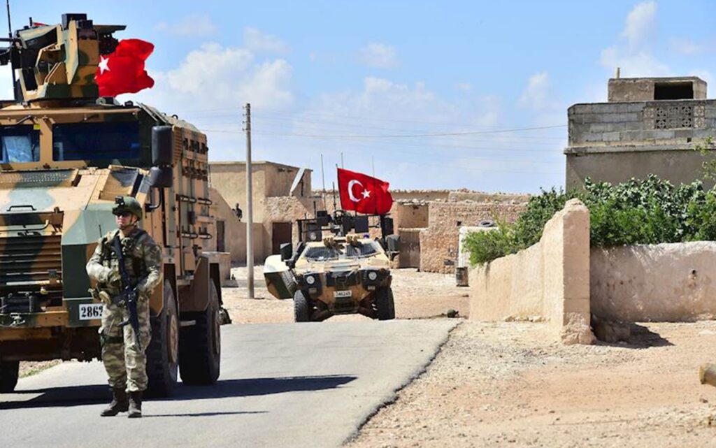 Turkish soldiers accompanied by armoured vehicles patrolling between the city of Manbij in northern Syria and an area it controls after a 2016-2017 military incursion on June 18, 2018. Turkey said it had started military patrols in an area around the Kurdish-held city of Manbij, in line with an agreement with the United States to scale down tensions in the region. / AFP PHOTO / AFP PHOTO AND TURKISH ARMED FORCES / Handout