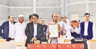 Chief Adviser Mohammad Yunus holds up the July Charter, flanked by leaders of different political parties, including BNP Secretary-General Mirza Fakhrul Islam Alamgir, after the signing of the Charter at a grand event on the Parliament premises in the city on 17 October 2025.